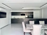 3 Bedroom House for Sale at Hillside Village Pattaya modern kitchen with dark cabinetry and marble dining table