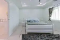 4 Bedroom House for Sale in East Pattaya pastel green guest bedroom with white bed frame and plush rug