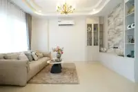 3 Bedroom House for Sale at Phonthep Garden Ville 2 bright living room with beige sofa gold chandelier and marble feature wall