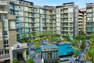 Apus condo aerial view showing multi-storey building exterior with central swimming pool and tropical gardens in Pattaya