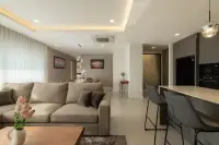 3 Bedroom Condo for Sale at Zensiri Estates and Residences bright living room with beige sofa, bar counter, and built-in black appliances