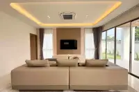 3 Bedroom House for Rent at Horizon By Patta living room with wall-mounted TV, ambient cove lighting, and sliding glass doors to garden