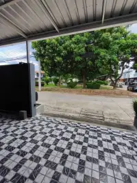 2 Bedroom House for Rent in Pong carport view with black gate opening to tree-lined street