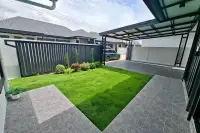3 Bedroom House for Rent in Huai Yai front yard with carport, artificial grass, and landscaped garden
