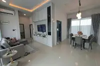 3 Bedroom House for Rent in Huai Yai open-plan living and dining area with white cabinetry and tiled flooring