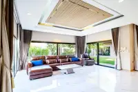 3 Bedroom House for Rent in Huai Yai spacious living room with leather sofa and garden view windows