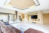 3 Bedroom House for Rent in Huai Yai open living area with TV wall unit and view into kitchen