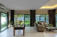 3 Bedroom House for Rent in Huai Yai open-plan dining and living area with garden and pool views