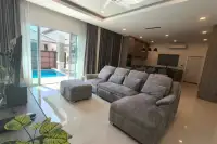 3 Bedroom House for Rent in Huai Yai open-plan living room with sectional sofa and pool view