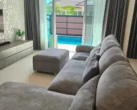3 Bedroom House for Rent in Huai Yai living area with sofa facing sliding doors to the pool