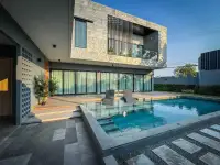 4 Bedroom House for Rent in Huai Yai poolside deck with loungers and glass sliding doors