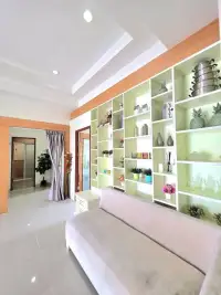 4 Bedroom House for Rent in Huai Yai lounge area with decorative green and white display shelving