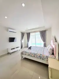4 Bedroom House for Rent in Huai Yai bright bedroom with double bed, TV, and pool view window