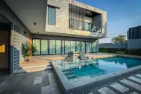 4 Bedroom House for Rent in Huai Yai modern two-story villa with private pool and sun loungers at sunset