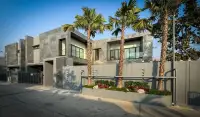 4 Bedroom House for Rent in Huai Yai exterior view with stone facade, gated entrance and palm trees