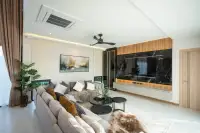 4 Bedroom House for Rent in Huai Yai living room with large sofa and marble feature wall with TV