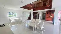5 Bedroom House for Rent in Huai Yai open living and dining area with white furniture and staircase to upper floor