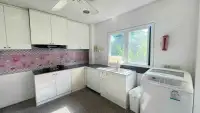 5 Bedroom House for Rent in Huai Yai kitchen with pink tiled backsplash, white cabinets and washing machine