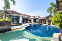 5 Bedroom House for Sale & Rent in Huai Yai curved swimming pool with tiled steps and tropical palm landscaping