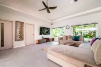 5 Bedroom House for Sale & Rent in Huai Yai spacious bedroom lounge area with large bed, sofa, and garden-view windows