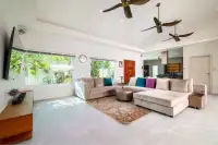 5 Bedroom House for Sale & Rent in Huai Yai living room with sectional sofa, ceiling fans, and open kitchen view