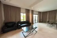 2 Bedroom House for Rent in Huai Yai living room with black leather sofas and glass coffee table