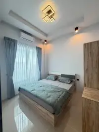 3 Bedroom Townhouse for Rent in Huai Yai bedroom with queen bed and wood accent wardrobe