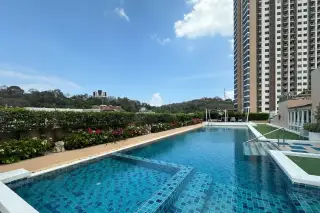 Hyde Park Residence 2 rooftop swimming pool with blue tiles, surrounded by green hedges and a tall building.