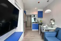 1 Bedroom Condo for Sale at The Twin Tower Jomtien Beach Pattaya compact kitchen with blue cabinets and large flat-screen TV