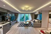 2 Bedroom Condo for Sale at Pristine Park 3 open-plan living area with integrated kitchen, gold chandelier, and garden-view balcony