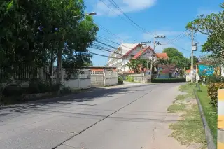 T.W. Wanasin traditional Thai-style guardhouse or small building with a tiled roof and surrounding trees.
