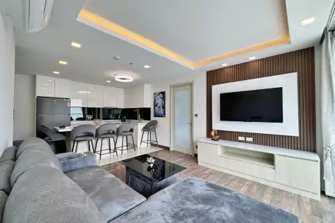 2 Bedroom Condo for Sale at The Peak Towers open-plan living area with kitchen island and wall-mounted TV