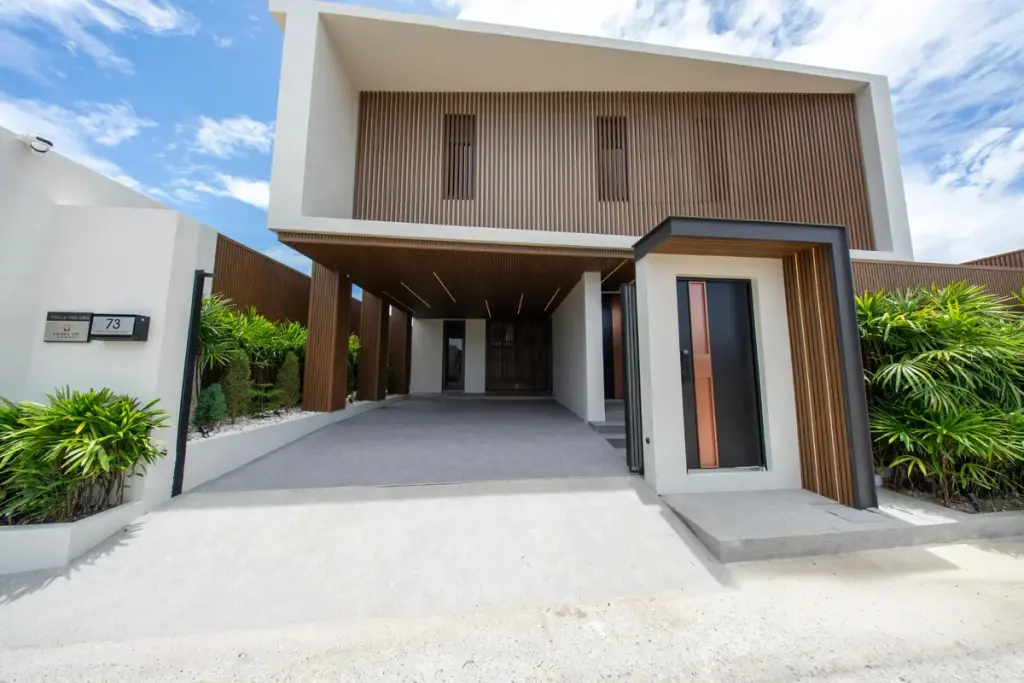 5 Bedroom House for Sale in Bang Lamung modern two-storey exterior with wood slat facade, covered carport and front entrance
