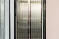 2 Bedroom Condo for Sale at Embassy Life close-up of ribbed frosted glass wardrobe doors with black metal frame