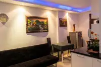 2 Bedroom Condo for Rent at Wongamat Privacy living and dining area with blue LED accent ceiling, wall paintings and dark sofa