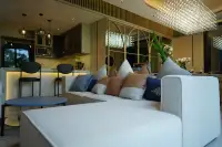 2 Bedroom Condo for Sale at SKYPARK Lucean Jomtien Pattaya modern living room with white sofa colorful cushions and open-plan kitchen with marble island