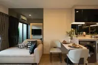 1 Bedroom Condo for Sale at The Indeed Condo Pattaya living room with sofa, dining chairs, and wall-mounted TV