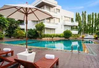 Rama Harbour View poolside deck with lounge chairs and umbrella overlooking marina