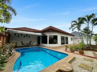 Siam Executive Estate backyard with curved swimming pool and covered patio seating area