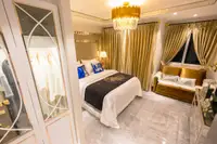 Studio Condo for Sale at Seven Seas Le Carnival: Overhead view of the bed with gold headboard, sofa, and gold curtains.