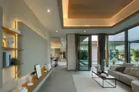 3 Bedroom House for Sale at Baan Pattaya 7 (Ascent) modern living room with large windows, sofa, coffee table, and decorative shelving.