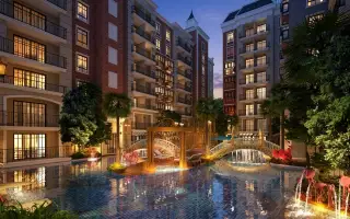 Espana Condo Resort illuminated buildings surrounding a large swimming pool with decorative bridges and fountains at dusk.