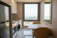 1 Bedroom Condo for Rent at Copacabana Beach Jomtien compact kitchen with fridge washing machine and dining table with sea view