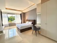 5 Bedroom House for Sale & Rent in Jomtien spacious bedroom with upholstered bed, desk, and large window