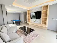 5 Bedroom House for Sale & Rent in Jomtien living room with pool table, gray sofa, and wall-mounted TV