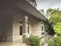 5 Bedroom House for Sale in Jomtien exterior stone-clad wall with dormer windows and garden path