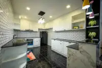 6 Bedroom House for Sale & Rent in Jomtien modern kitchen with white cabinetry and subway tile walls