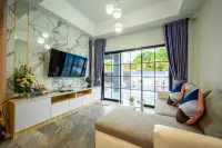 6 Bedroom House for Sale & Rent in Jomtien living room with marble TV wall and pool view through glass doors