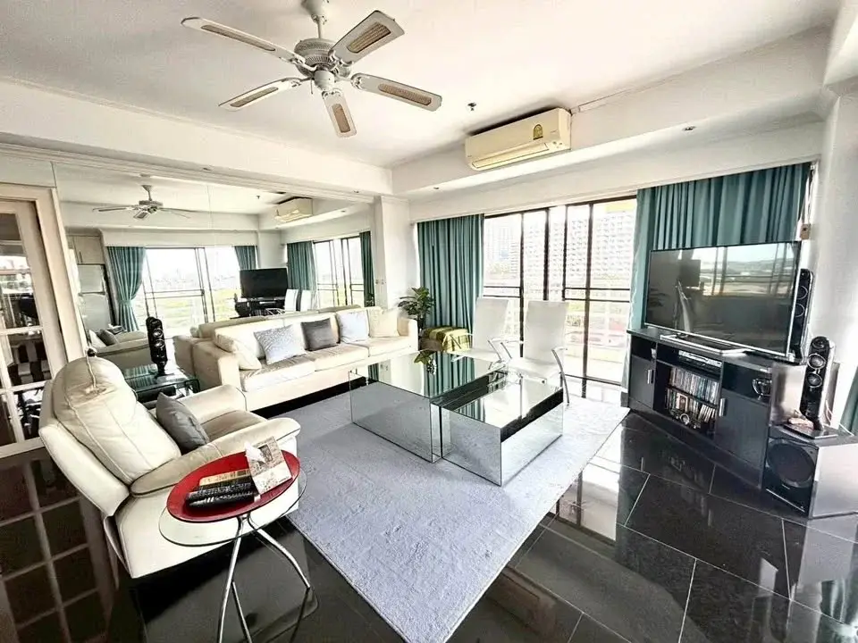 2 Bedroom Condo for Sale at Jomtien Beach Condominium living room with mirrored coffee tables and balcony view