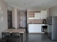2 Bedroom Condo for Sale at Jomtien Beach Condominium open-plan kitchen with white cabinets and dining table
